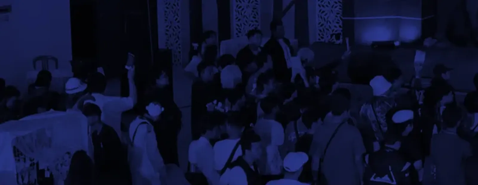 Lantai konvensi IMAGI yang dipenuhi pengunjung, difoto dari atas dan dilapis warna indigo.